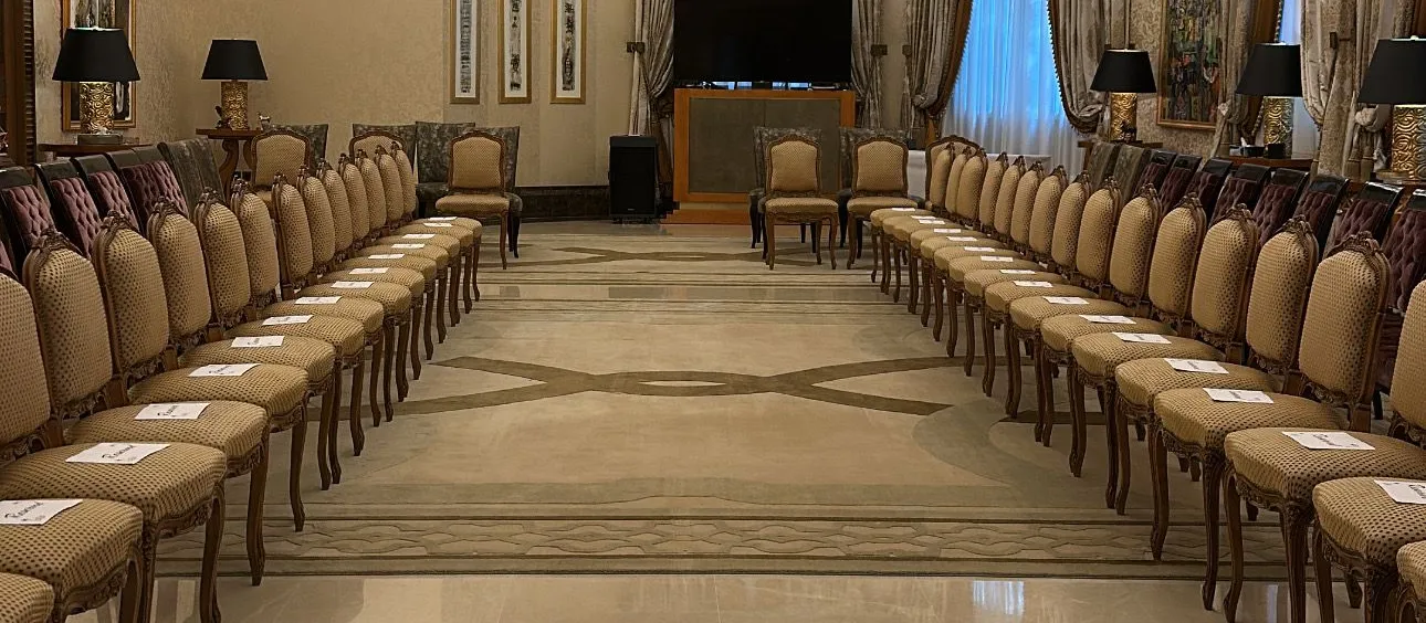 Salle de réception préparée avec des rangées de chaises et un lustre